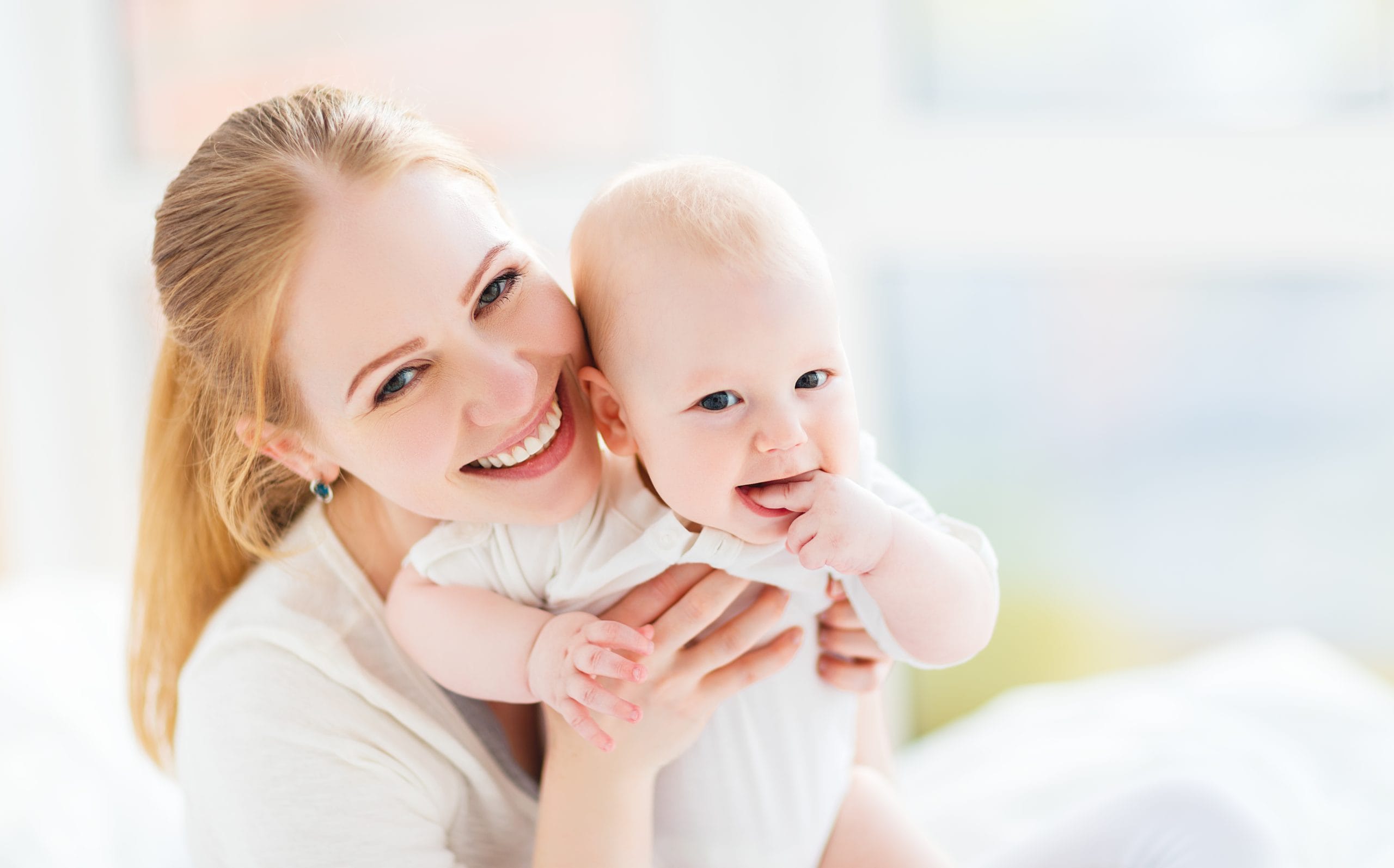 Expert newborn care specialist holding infant in luxury Delray Beach nursery
